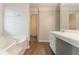 Bright bathroom with wood floor, a soaking tub, and access to a walk-in closet at 6683 Princeton Park Ct, Lithonia, GA 30058