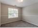 Empty bedroom with neutral walls, carpeted floor, and a window for natural light at 6683 Princeton Park Ct, Lithonia, GA 30058