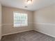 Neutral bedroom with gray carpeting and a bright window at 6683 Princeton Park Ct, Lithonia, GA 30058