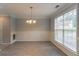 Dining room with wainscoting, modern chandelier, and a large window for natural light at 6683 Princeton Park Ct, Lithonia, GA 30058
