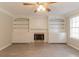 Cozy living room with a fireplace, mantel, built-in shelving, and wood-look flooring at 6683 Princeton Park Ct, Lithonia, GA 30058