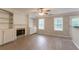 Living room showcasing wood-look flooring, fireplace, built-in shelving, and natural light at 6683 Princeton Park Ct, Lithonia, GA 30058