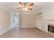 Bright living room featuring a ceiling fan, built-in shelves, cabinets, and fireplace at 6683 Princeton Park Ct, Lithonia, GA 30058