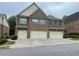 View of the exterior of the townhome with a three-car garage, brick facade, and covered entrance at 805 Pleasant Hill Nw Rd # 53, Lilburn, GA 30047
