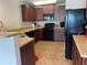 Kitchen featuring wood cabinets and black appliances with tiled floors and light countertops at 805 Pleasant Hill Nw Rd # 53, Lilburn, GA 30047