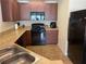 Spacious kitchen with dark wooden cabinets, black appliances, and light countertops at 805 Pleasant Hill Nw Rd # 53, Lilburn, GA 30047