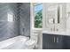 Stylish bathroom with gray herringbone tile, white vanity, and modern fixtures at 115 Thome Dr, Alpharetta, GA 30022
