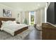 Inviting bedroom with wood flooring, plush rug, and a view of the landscaped front yard at 115 Thome Dr, Alpharetta, GA 30022