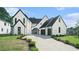 Charming two-story home featuring a manicured lawn and eye-catching black and white design at 115 Thome Dr, Alpharetta, GA 30022