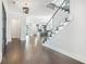 Stylish foyer with glass-railed staircase, dark wood floors, and open layout leading to a modern kitchen at 115 Thome Dr, Alpharetta, GA 30022