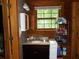 Rustic bathroom featuring a wooden vanity with granite countertop and natural light from a window at 3096 Campground Rd, Winston, GA 30187