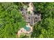 Lush landscaping surrounds the estate with a pool and stone patio in a private setting at 4161 Thunderbird Se Dr, Marietta, GA 30067