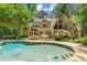 Private backyard showcasing a pool, stone patio, landscaped yard, and mature trees at 4161 Thunderbird Se Dr, Marietta, GA 30067
