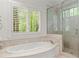 Bright bathroom with large tub and glass enclosed shower offering outdoor views at 4161 Thunderbird Se Dr, Marietta, GA 30067