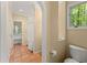 Hallway leading to an accessible toilet and walk-in shower with tile flooring and natural light at 4161 Thunderbird Se Dr, Marietta, GA 30067