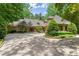 Charming home featuring a circular driveway, mature trees, and lush landscaping creating a private oasis at 4161 Thunderbird Se Dr, Marietta, GA 30067