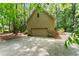 Side-angled exterior view of a home's garage with a concrete driveway and surrounding lush trees at 4161 Thunderbird Se Dr, Marietta, GA 30067