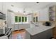 Bright kitchen featuring white cabinets, tiled floors, and a large window with views of the lush greenery at 4161 Thunderbird Se Dr, Marietta, GA 30067