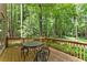 Outdoor dining area on a wood patio surrounded by a lush, green forest at 4161 Thunderbird Se Dr, Marietta, GA 30067