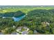 Scenic aerial view of lakefront homes nestled among lush trees, offering a serene and picturesque setting at 6625 Baywood Run, Cumming, GA 30041