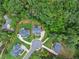 Aerial view of a luxurious home with a circular driveway nestled in a lush green landscape at 6625 Baywood Run, Cumming, GA 30041