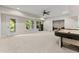 Spacious basement featuring neutral carpeting, a ceiling fan, and an exterior door to the outside at 6625 Baywood Run, Cumming, GA 30041