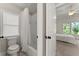 Cozy bathroom with tub-shower combo, toilet, and a bright window at 6625 Baywood Run, Cumming, GA 30041