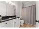 Bright bathroom featuring a white vanity with black countertop, and a shower with a neutral shower curtain at 6625 Baywood Run, Cumming, GA 30041