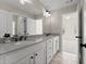 Stylish bathroom with double vanity, modern fixtures, and a view into the bedroom at 6625 Baywood Run, Cumming, GA 30041