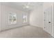 Bright bedroom with plush carpet, ceiling fan, and two windows with white shutters at 6625 Baywood Run, Cumming, GA 30041