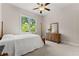 Bedroom with carpet flooring, ceiling fan, and a window with a view of lush greenery at 6625 Baywood Run, Cumming, GA 30041