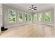 Empty room with hardwood floors, a ceiling fan, and several windows with bright, natural light at 6625 Baywood Run, Cumming, GA 30041