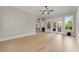 Large, empty room with hardwood floors, bright windows, and access to an outdoor deck at 6625 Baywood Run, Cumming, GA 30041