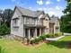 Stunning two-story home featuring a blend of stone and siding, a covered front porch, and manicured landscaping at 6625 Baywood Run, Cumming, GA 30041