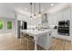Modern white kitchen featuring stainless appliances, a large center island, and hardwood floors at 6625 Baywood Run, Cumming, GA 30041