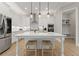 Bright and modern white kitchen with large center island, stainless appliances, and hardwood floors at 6625 Baywood Run, Cumming, GA 30041
