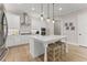 Bright white kitchen featuring stainless appliances, center island with seating, and hardwood floors at 6625 Baywood Run, Cumming, GA 30041