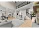 Open-concept living room featuring soaring ceilings, hardwood floors, and an adjacent open kitchen and staircase at 6625 Baywood Run, Cumming, GA 30041