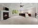 Bright main bedroom featuring a fireplace, tray ceiling, and large windows offering a picturesque view at 6625 Baywood Run, Cumming, GA 30041