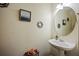 A well-lit powder room featuring a pedestal sink, mirror, and artwork at 780 Nehemiah Sw Ln, Atlanta, GA 30331