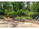 Charming backyard with raised garden beds, lounge chairs, and mature trees, creating a serene outdoor retreat at 1195 Russell Dr, Decatur, GA 30030