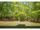 Scenic backyard with mature trees providing ample shade and a lush green lawn at 160 Vinnys Way, Covington, GA 30014