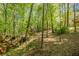 Spacious backyard featuring a custom playhouse nestled among mature trees at 160 Vinnys Way, Covington, GA 30014