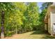 View of the home's exterior and backyard with lush green trees, complemented by the home's architectural details at 160 Vinnys Way, Covington, GA 30014