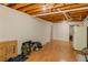 Unfinished basement area with wood floors, a white refrigerator, and open ceiling with exposed beams at 160 Vinnys Way, Covington, GA 30014