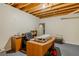 Basement office with a desk, ergonomic chair, office supplies, open ceiling and concrete floor at 160 Vinnys Way, Covington, GA 30014
