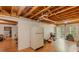 View of the basement, revealing unfinished ceiling, laminate flooring, white refrigerator and exterior access at 160 Vinnys Way, Covington, GA 30014