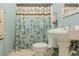 Bathroom featuring a pedestal sink, toilet, floral shower curtain, chrome hardware and blue walls at 160 Vinnys Way, Covington, GA 30014