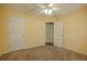 This bedroom offers neutral carpeting and an open door to another room, with ample space and a ceiling fan at 160 Vinnys Way, Covington, GA 30014