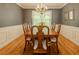 Formal dining room with hardwood floors, a classic chandelier, and elegant wainscoting at 160 Vinnys Way, Covington, GA 30014